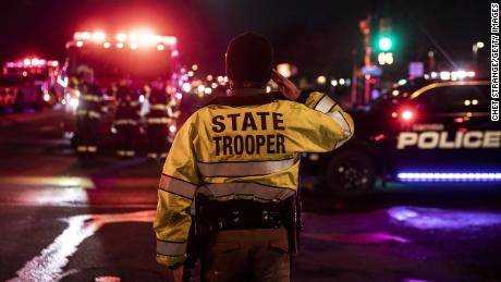 Ein Polizeibeamter des US-Bundesstaates Colorado begrüßt, als eine Prozession, die die Leiche eines Kollegen trägt, das Lebensmittelgeschäft von König Sooper verlässt.