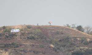 Ein Anhänger Indiens schwenkt seine Flagge von einem Hügel über das Stadion.