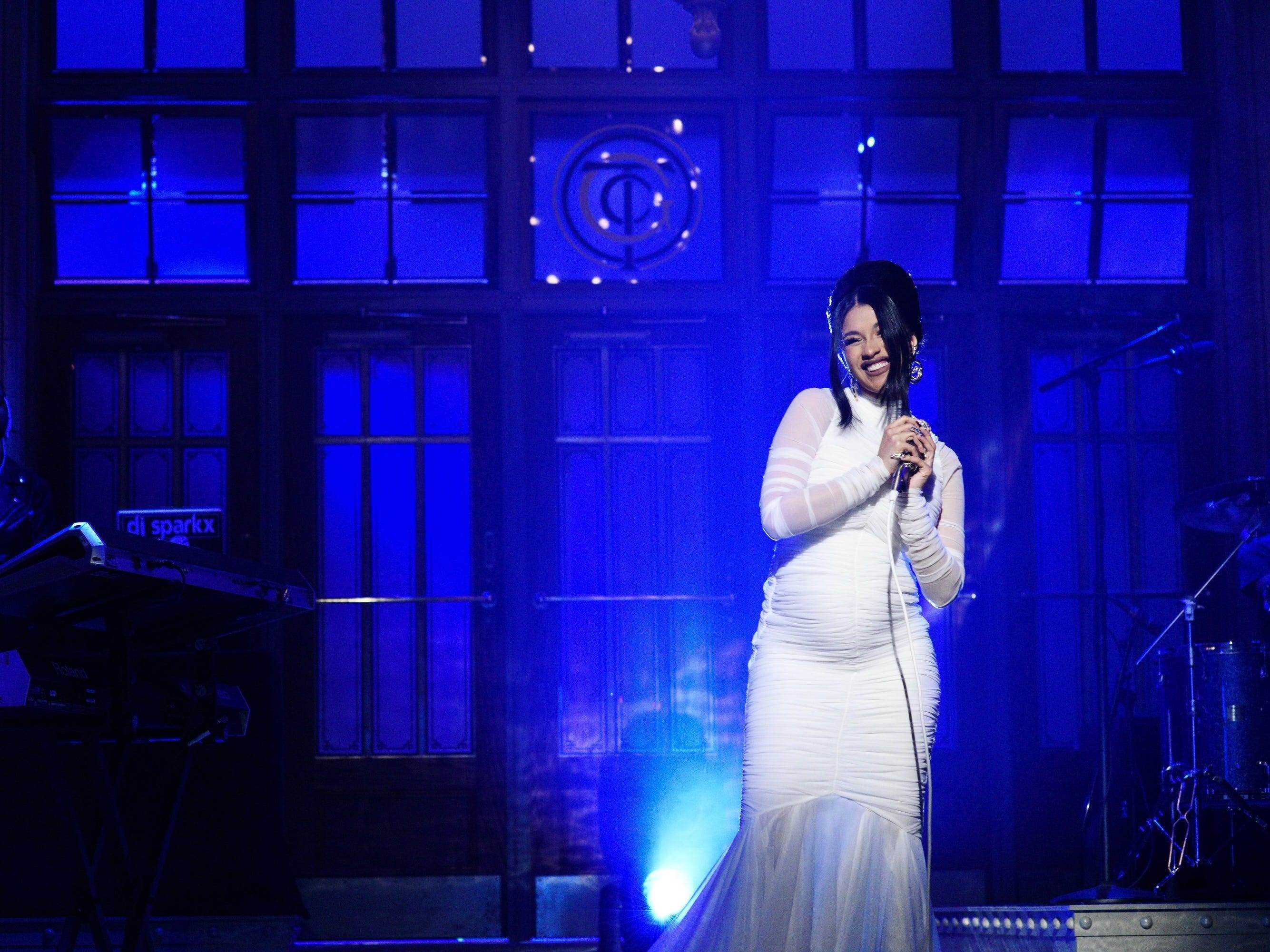 Cardi B auf der Bühne des SNL trägt ein weißes Kleid mit Babybauch.