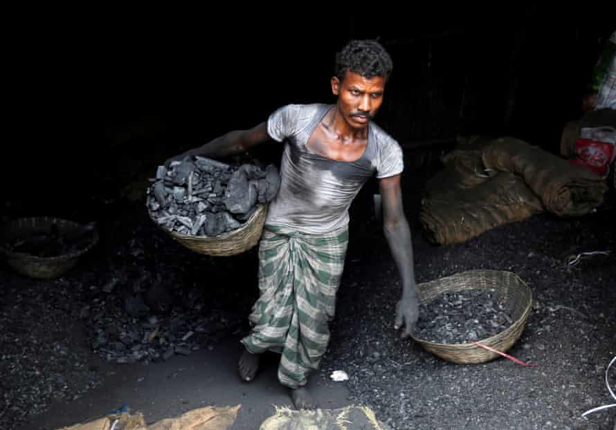 Ein Arbeiter trägt Kohle in einem Korb in einem Industriegebiet in Mumbai.