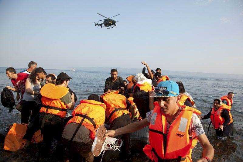 Frontex-Hubschrauberpatrouillen über syrische Flüchtlinge, die auf einem überfüllten Schlauchboot an einem Strand auf der griechischen Insel Lesbos ankommen, 10. August 2015. REUTERS/Antonis Pasvantis