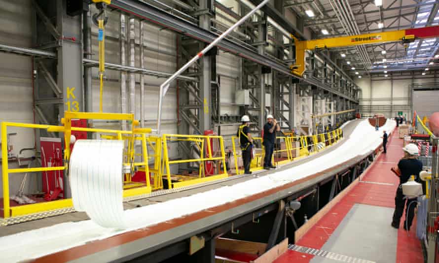 Arbeiter im Siemens-Werk Gamesa rollen Glasfaser- und Balsaholzschichten in 81-Meter-Formen aus, bevor Harze und Farbe hinzugefügt werden.