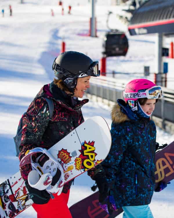Mutter und Tochter tragen ihre Snowboards zum Skilift