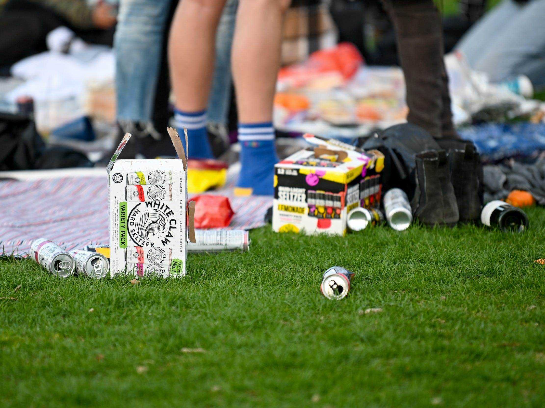 Leere White Claw und Bud Light Seltzer Dosen auf dem Boden im Central Park während des Picknicks