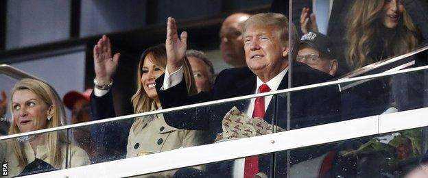 Der frühere US-Präsident Donald Trump macht während des Spiels die Geste 