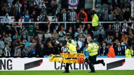 Sanitäter laufen mit einer Trage, um eine Person in der Menge während des Spiels zwischen Newcastle und Tottenham Hotspur zu behandeln.