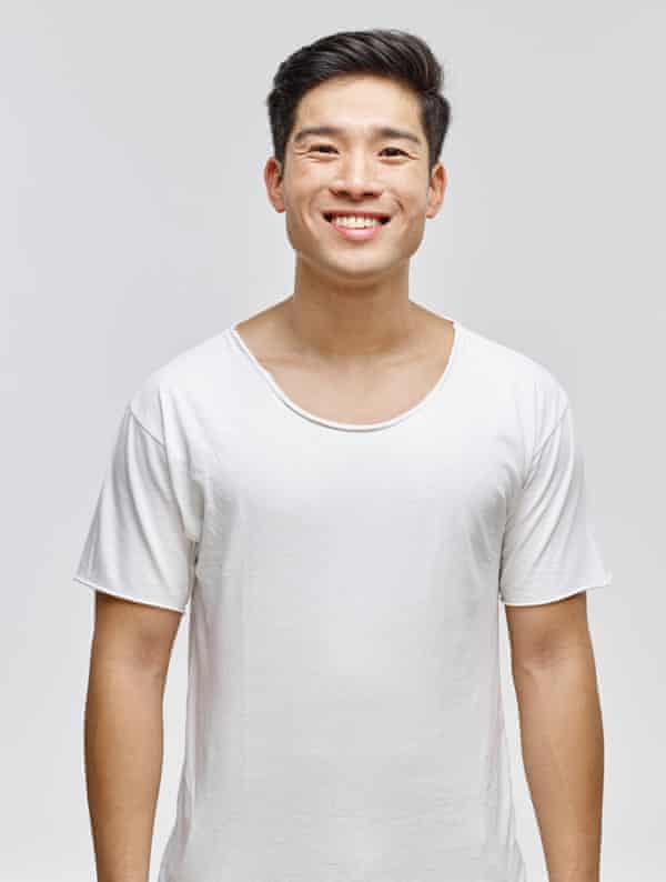 Ein junger Mann, der ein weißes Baumwoll-T-Shirt mit roh geschnittenen Ärmeln und Kragen trägt.