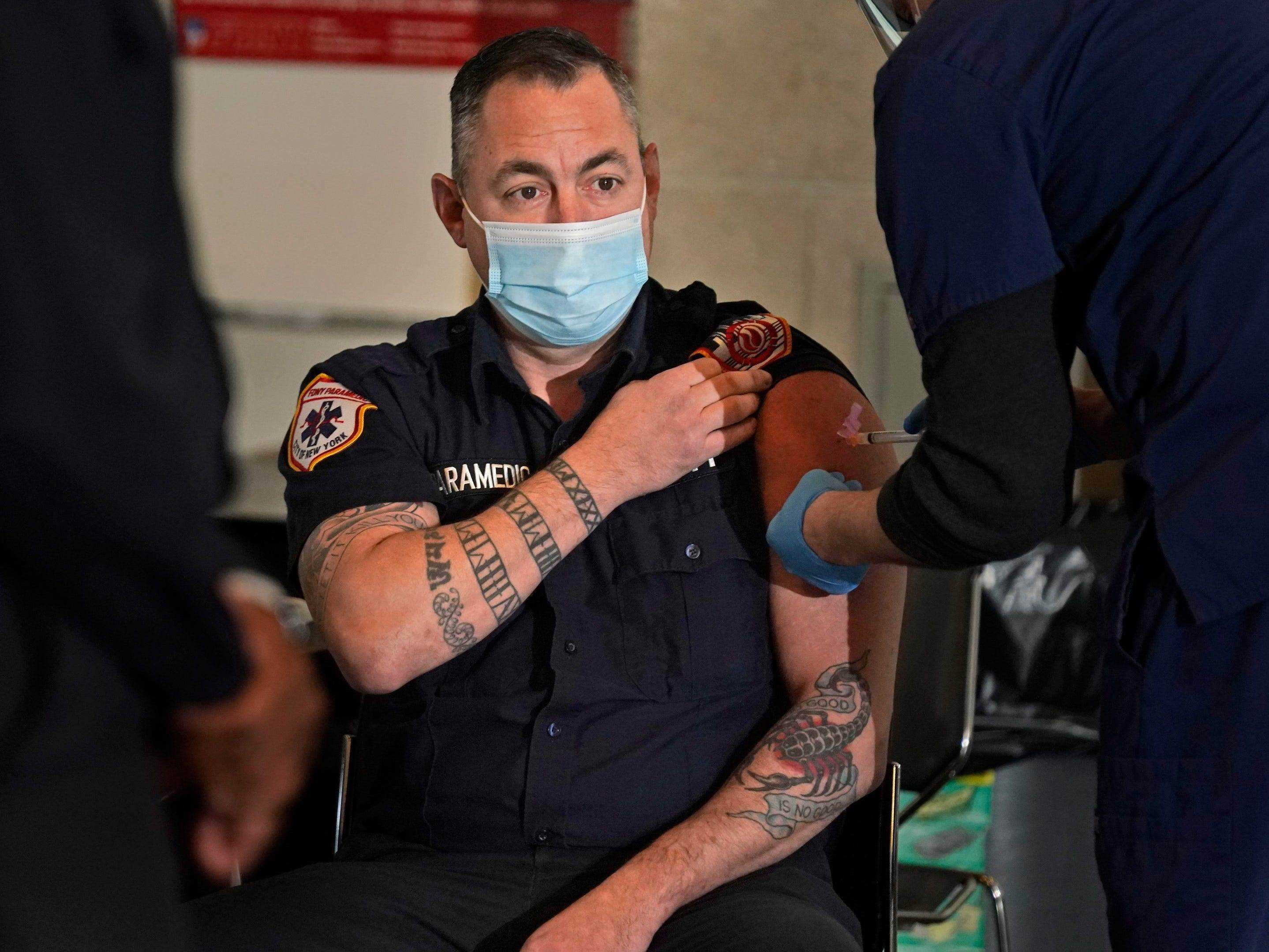 Ein Rettungssanitäter der New Yorker Feuerwehr wird geimpft.
