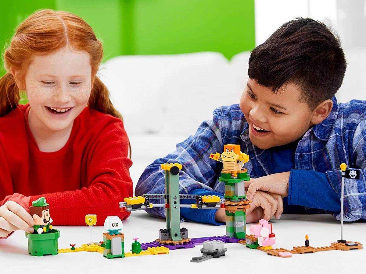 Ein Junge und ein Mädchen spielen mit dem LEGO Super Mario Adventures mit Luigi Starter Course Kit