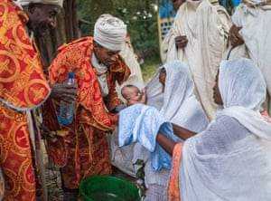 Ein Baby wird an einem Sonntagmorgen vor der göttlichen Liturgie in der Kirche von Robit Bahita getauft