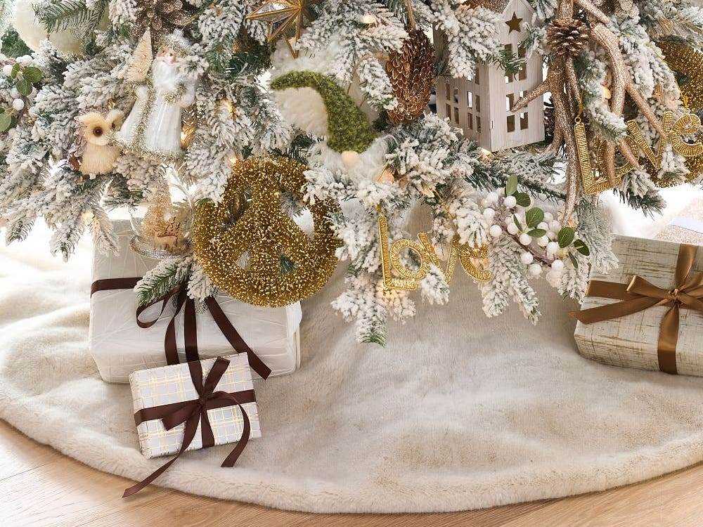 Bild eines weißen Baumrocks unter einem beflockten Weihnachtsbaum für die besten Weihnachtsbaumröcke im Jahr 2021