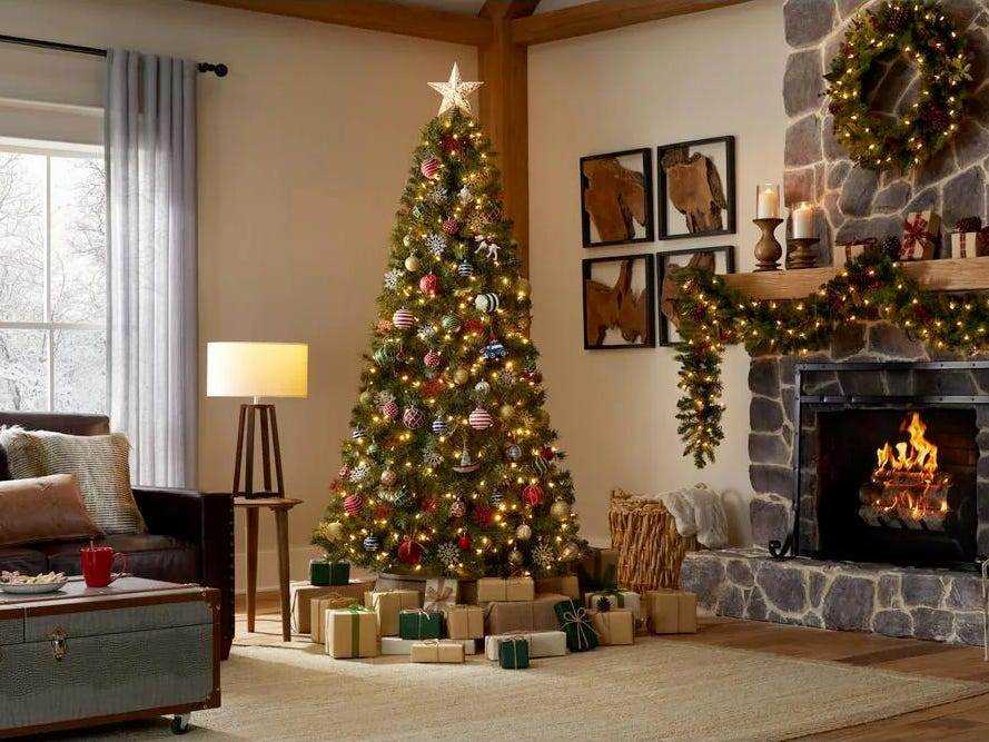 Bild von Home Accents Holiday vorbeleuchteter Weihnachtsbaum im Wohnzimmer neben dem Kamin für den besten vorbeleuchteten Weihnachtsbaum 2021