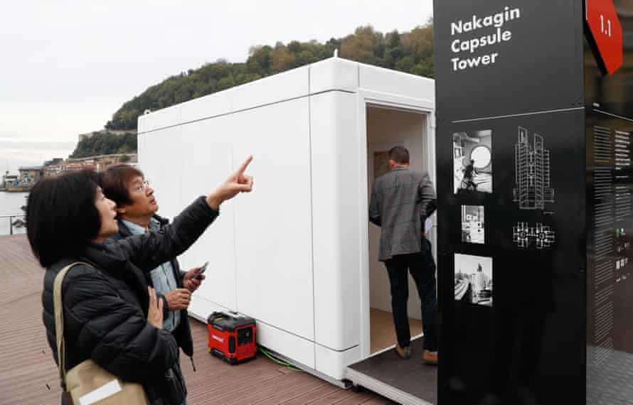 Touristen in Spanien betrachten eine Kopie einer der Kapseln des Nakagin Tower in Tokio in Originalgröße