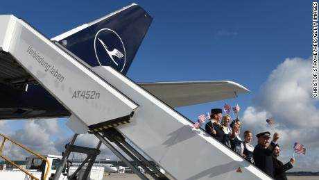 Lufthansa-Besatzungsmitglieder vor einem Flug von München nach Miami, während europäische Reisende die Wiedereröffnung der US-Grenzen feiern.