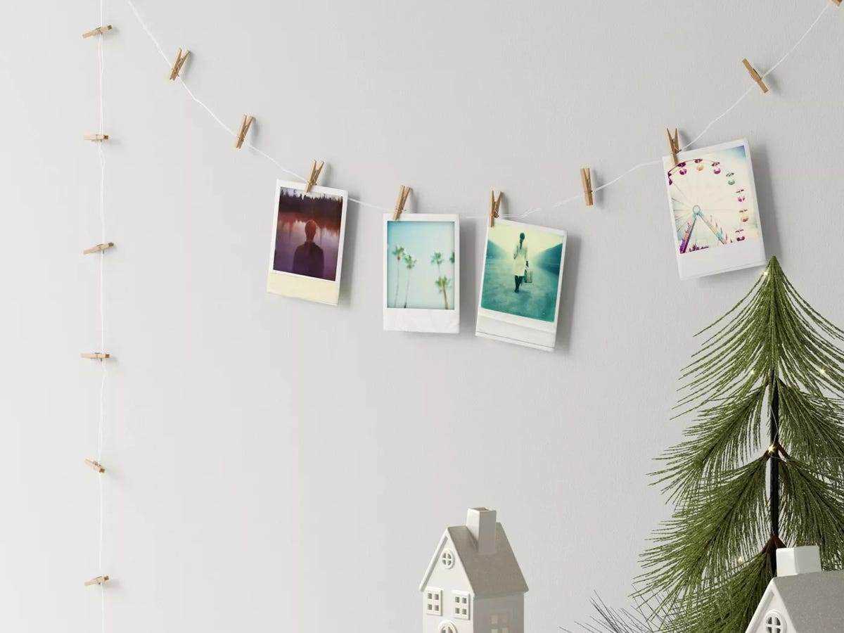 Lichterketten mit aufgesteckten Polaroidfotos an der Wand aufgereiht