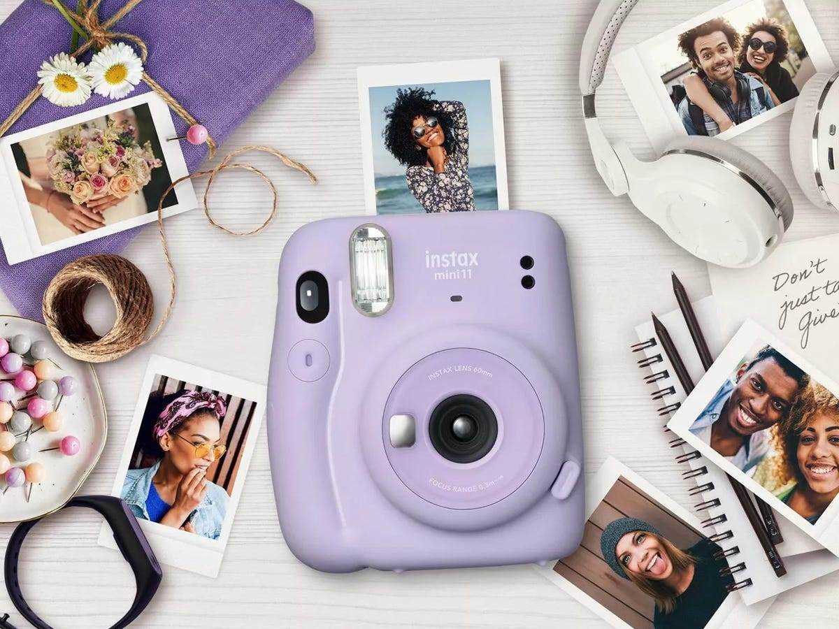 Lavendel Fuji Film Instax Mini-Kamera umgeben von Fotos