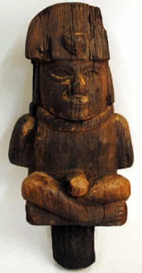 Eine Holzfigur, die einen gefesselten Gefangenen mit einem Seil um den Hals darstellt.