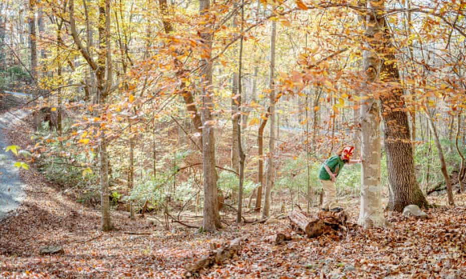 Newton, ein Junge mit Autismus-Spektrum, in einem Wald, mit einer rot-weißen Maske, 2015
