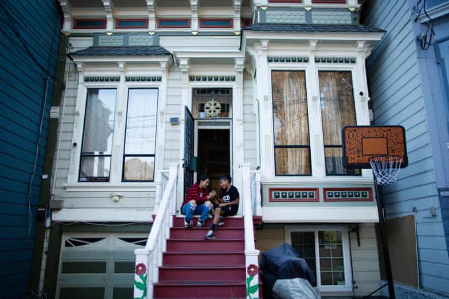Cousins ​​Maggie Guillen, 12, links, und Noe Zuleta, 14, sitzen auf den vorderen Stufen ihres Hauses im Missionsviertel.