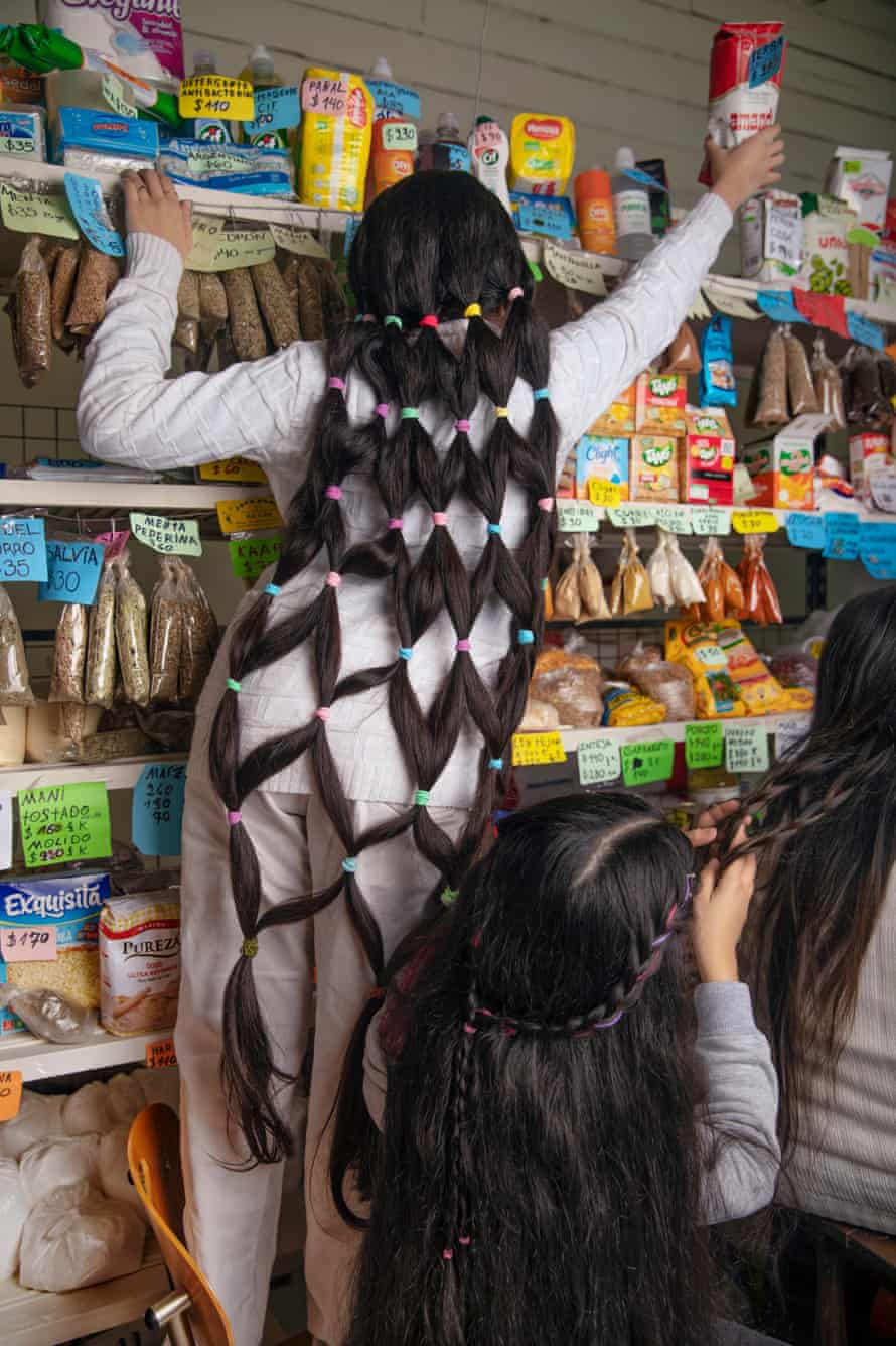 Antonella Bordon mit ihren langen Haaren geflochten und frisiert, hilft im Laden ihrer Eltern