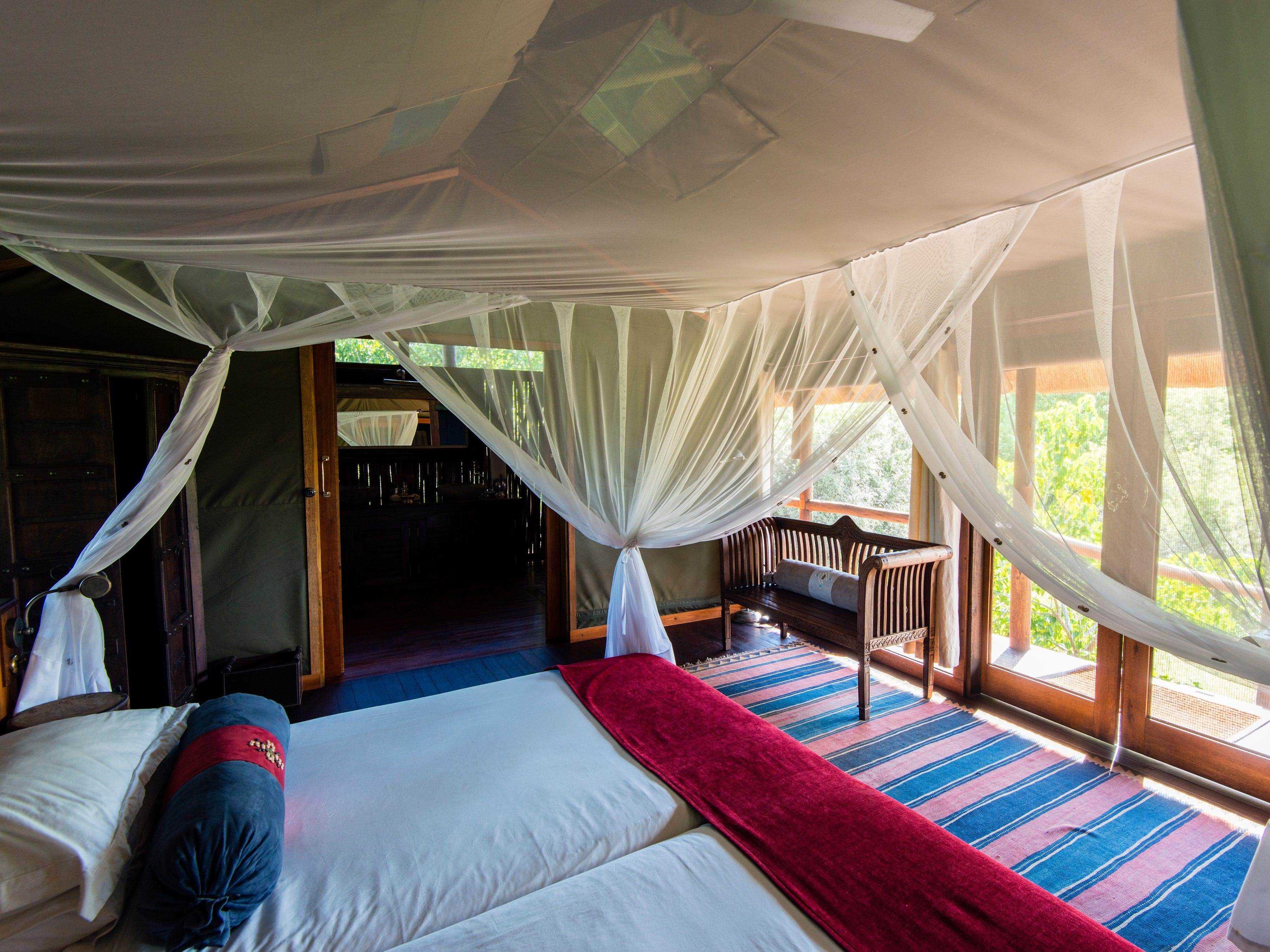 Ein Moskitonetz um ein Bett in einem luxuriösen Safaricamp-Zelt.