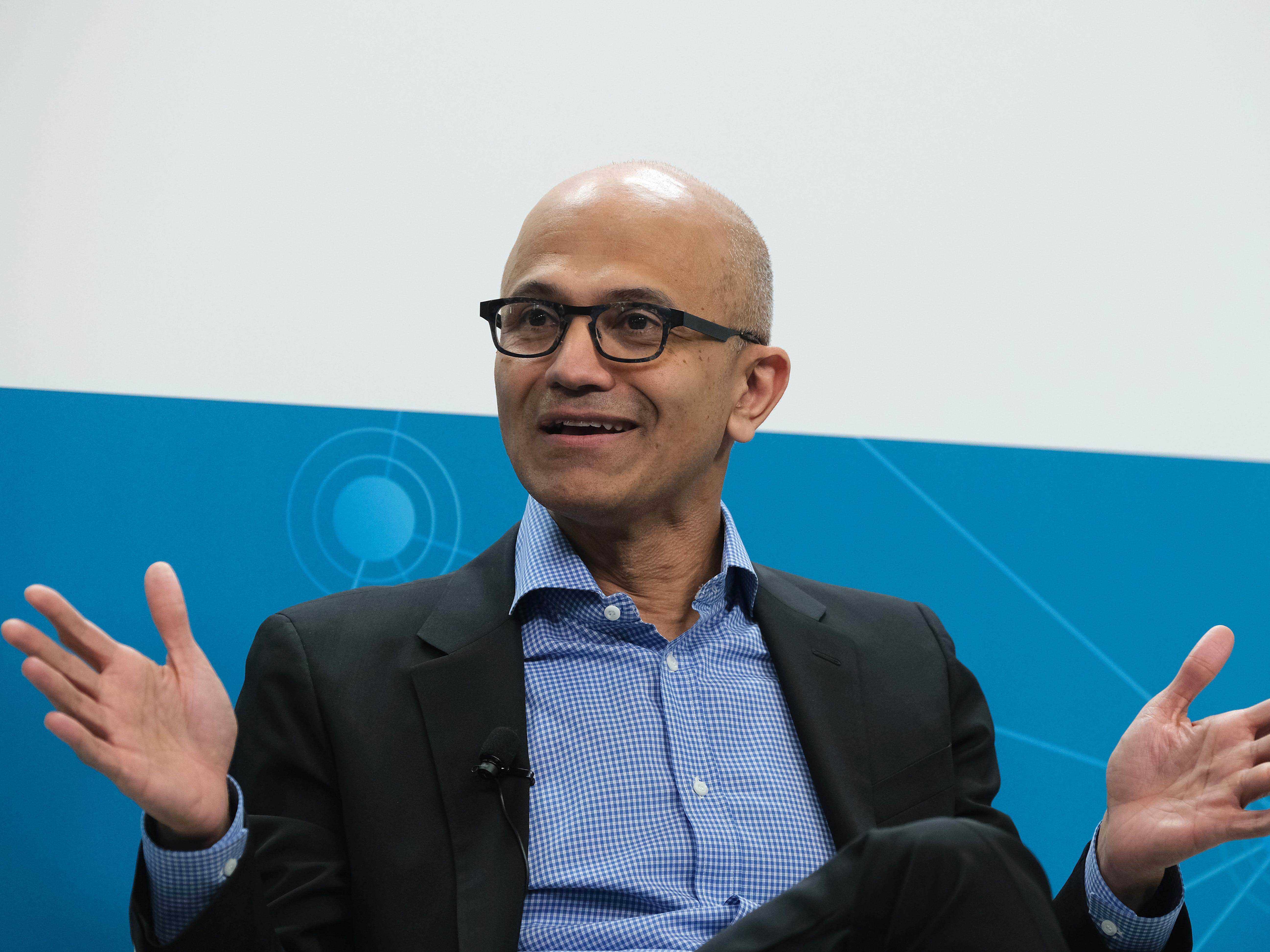 Microsoft-Chef Satya Nadella, sitzt mit offenen Händen.