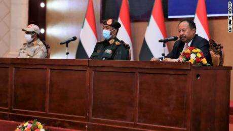 Premierminister Abdalla Hamdok sitzt neben dem obersten General des Sudan, Abdel Fattah Al-Burhan, als er bei einer Zeremonie spricht, die ihn am 21.