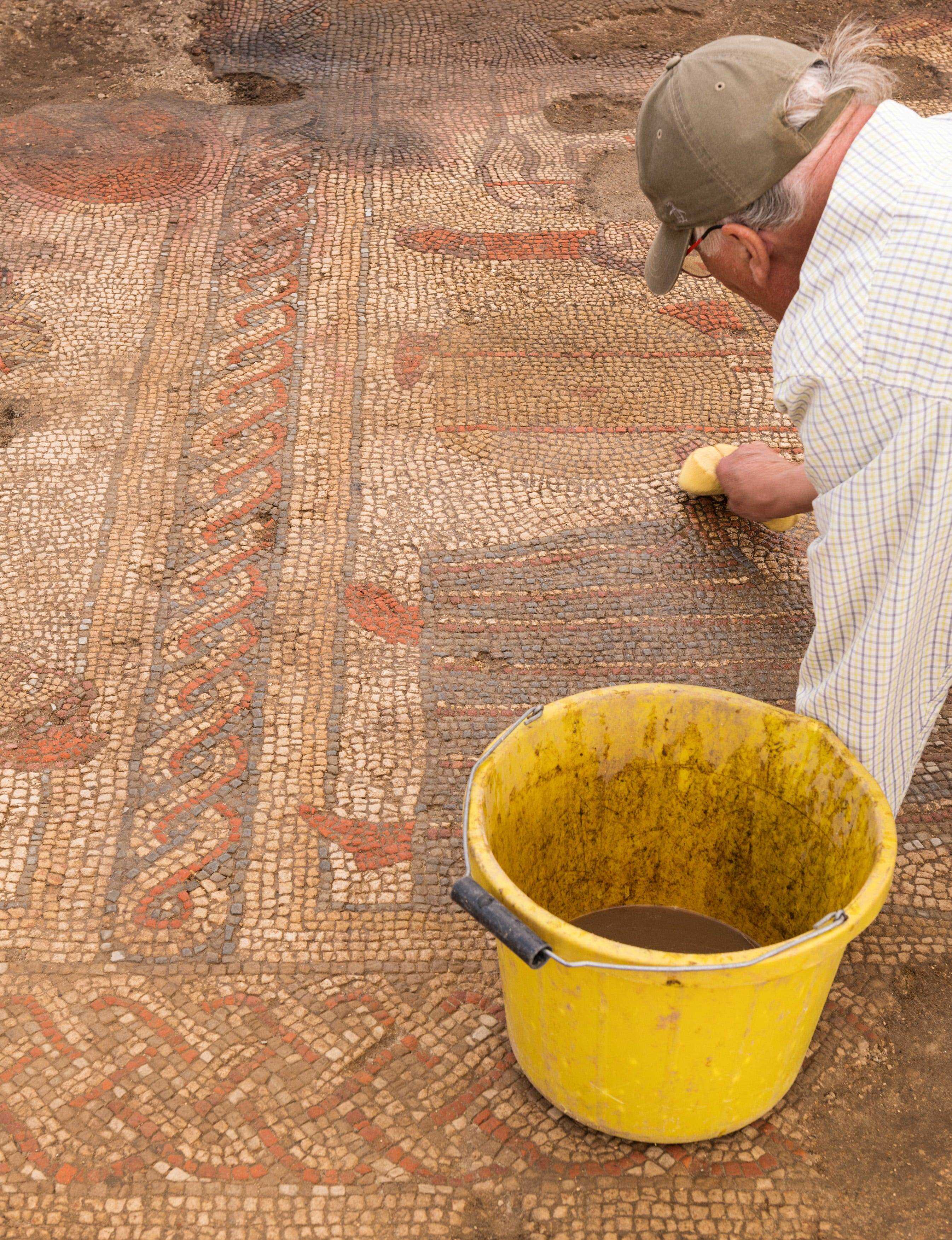 Ein Mitglied des Teams der ULAS/University of Leicester bei den Ausgrabungen eines Mosaikpflasters.