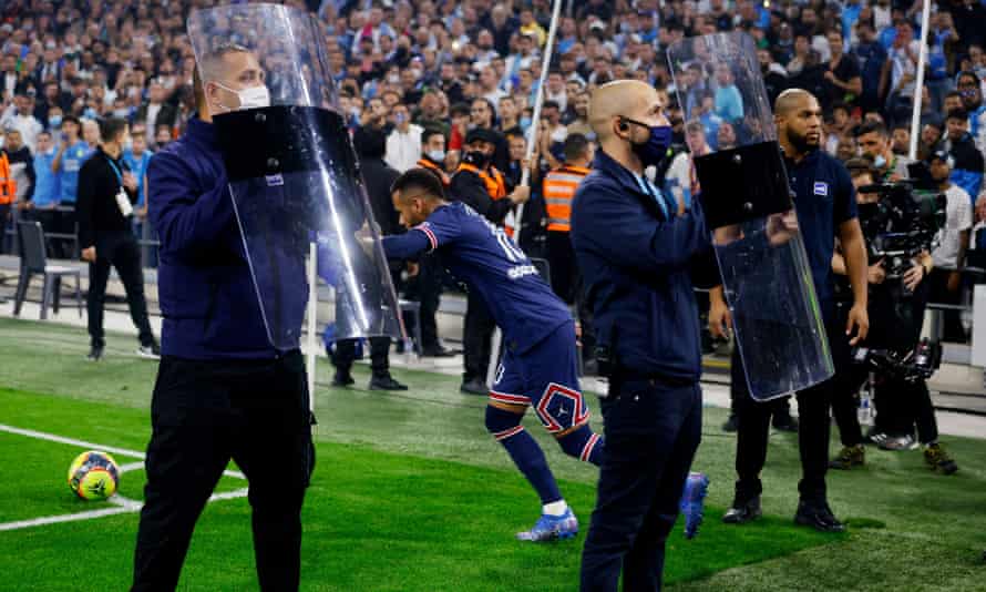 Sicherheitspersonal hält Schutzschilde, um Neymar von Paris Saint-Germain vor Gegenständen zu schützen, die von Marseille-Anhängern geworfen wurden
