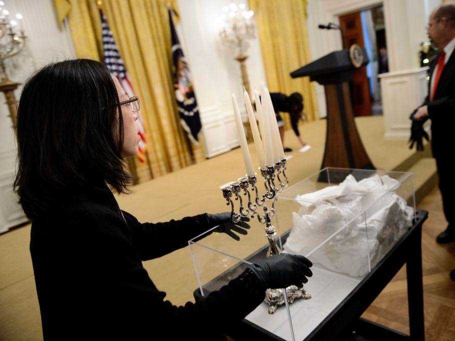Ein Mitarbeiter des Weißen Hauses bringt vor der Chanukka-Party des Weißen Hauses eine Menora in den East Room.