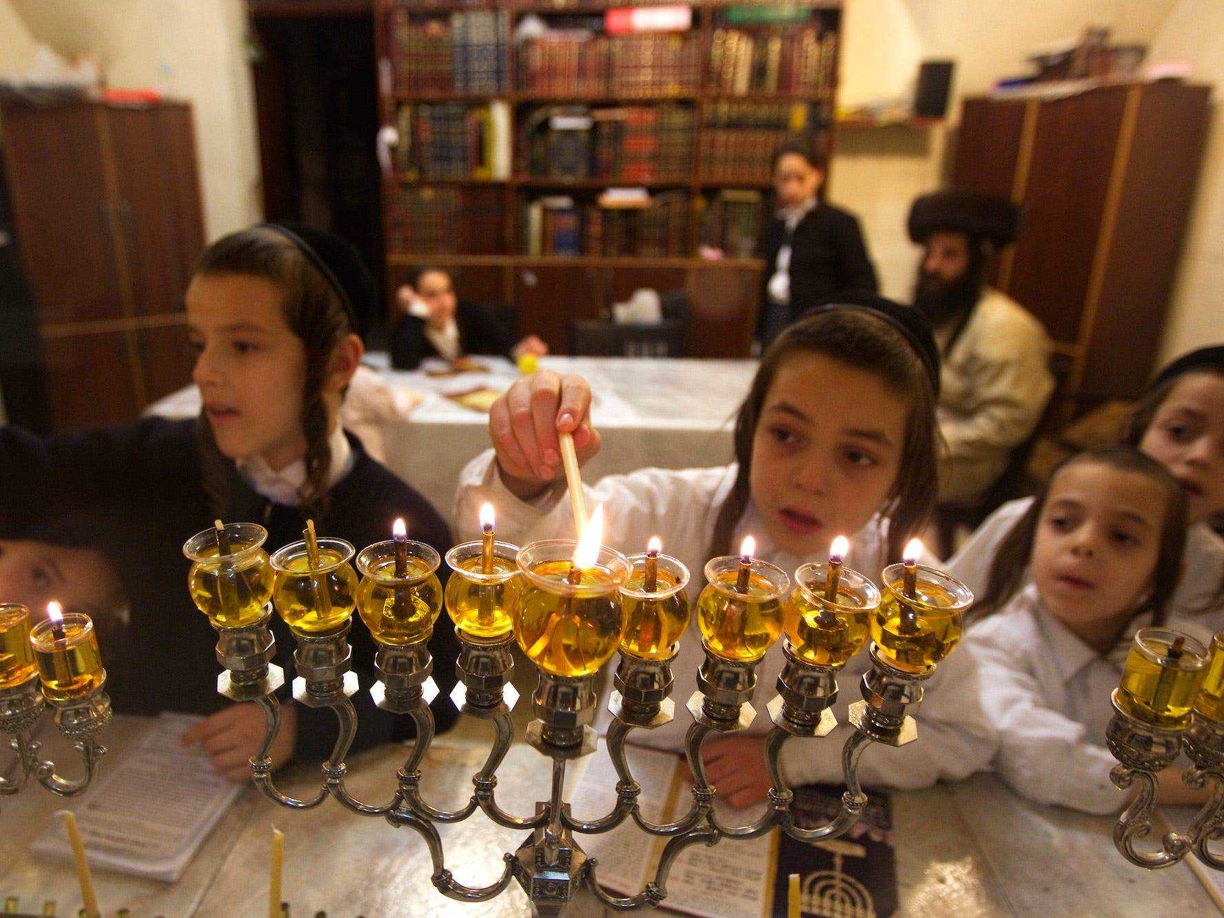 Eine jüdische Familie zündet zum Chanukka-Fest Kerzen an.