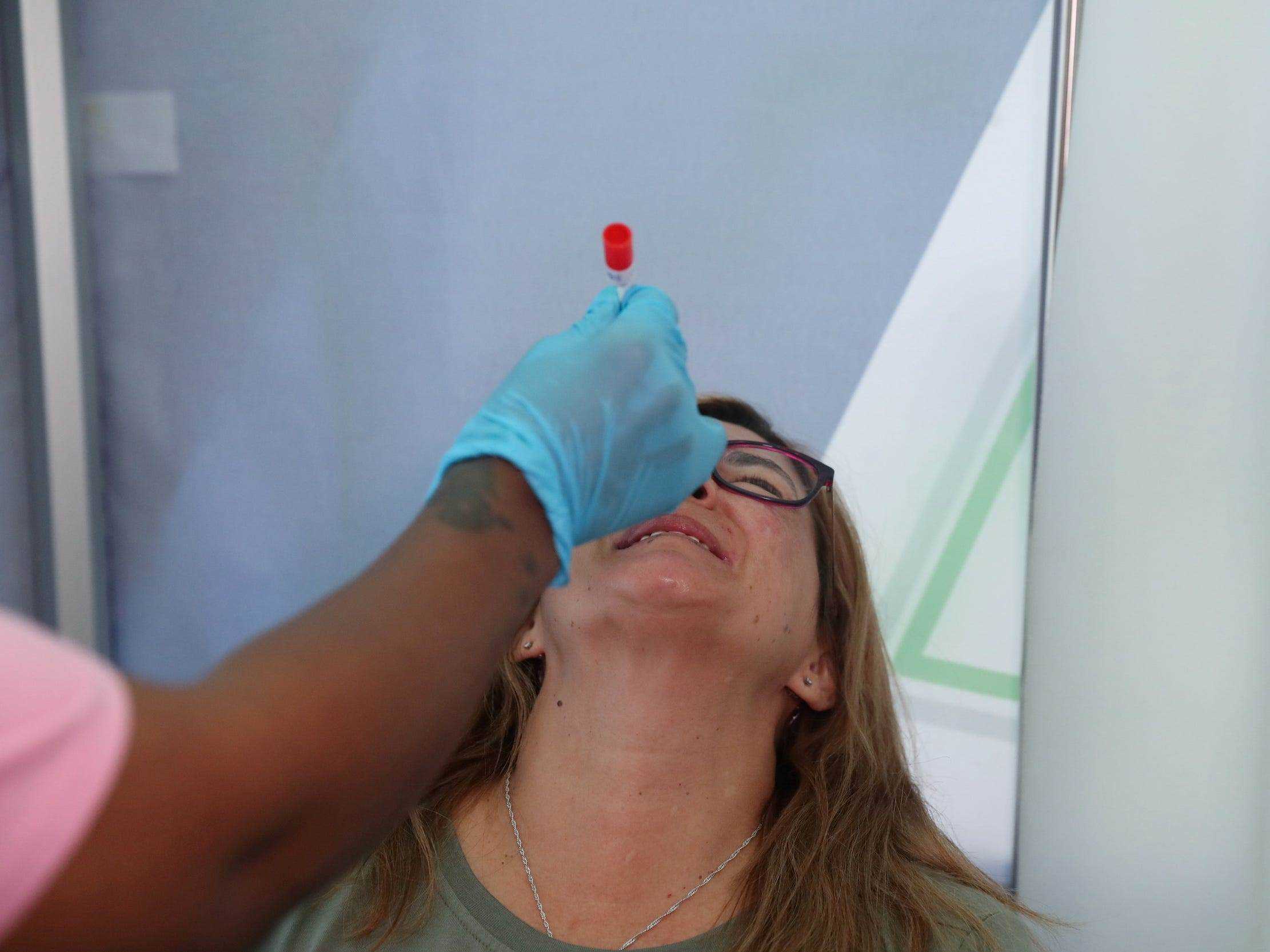 Gesundheitspersonal in Johannesburg, Südafrika, macht einem Reisenden einen Covid-Test, während sich die Omicron-Variante ausbreitet