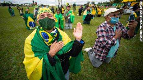 Unterstützer des brasilianischen Präsidenten Jair Bolsonaro beten während einer Autokolonne und protestieren gegen den Nationalkongress und den Obersten Gerichtshof gegen Sperrmaßnahmen inmitten der Coronavirus-Pandemie (COVID-19) vor dem Nationalkongress am 09.