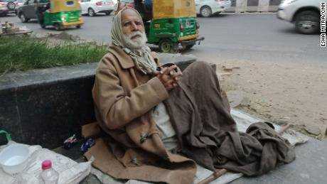 Gulpreet Singh bettelt vor der South Campus-Station in Delhi um Essen.  Er hat Mühe, die Verschmutzung einzuatmen. 