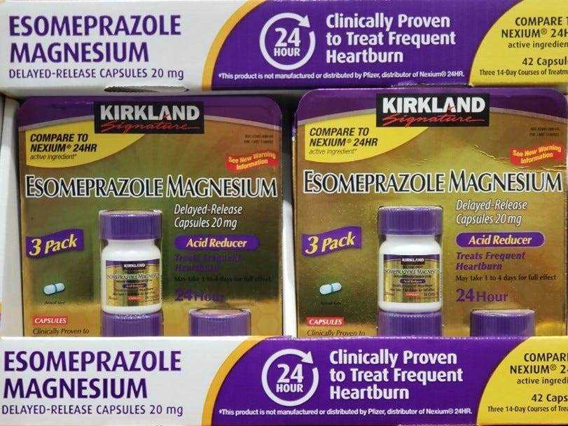 weiße, violette und gelbe Schachtel mit violetter und goldener Rückseite von Reflux-Medikamenten zum Selbstkostenpreis