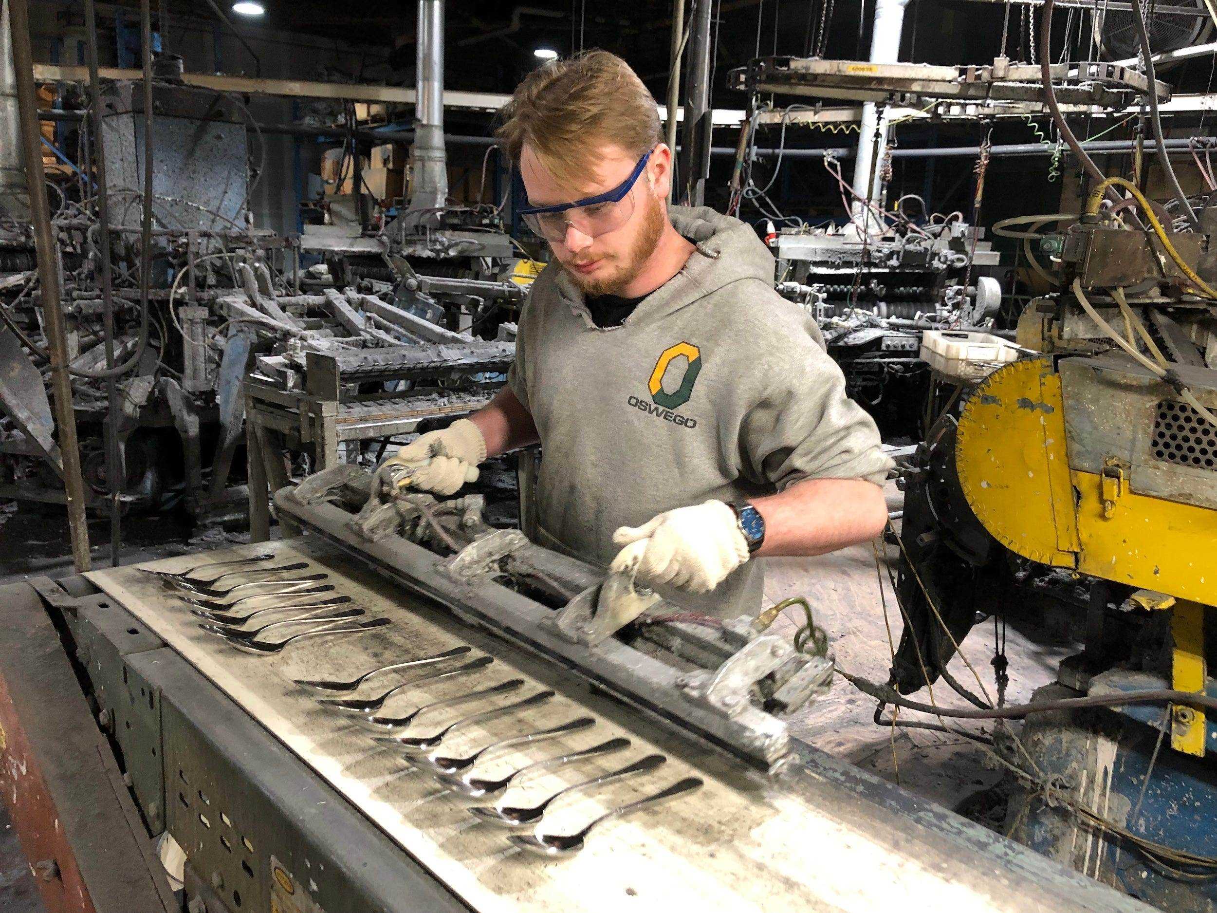 Mann arbeitet Maschinenherstellung von Löffeln bei Sherrill Manufacturing