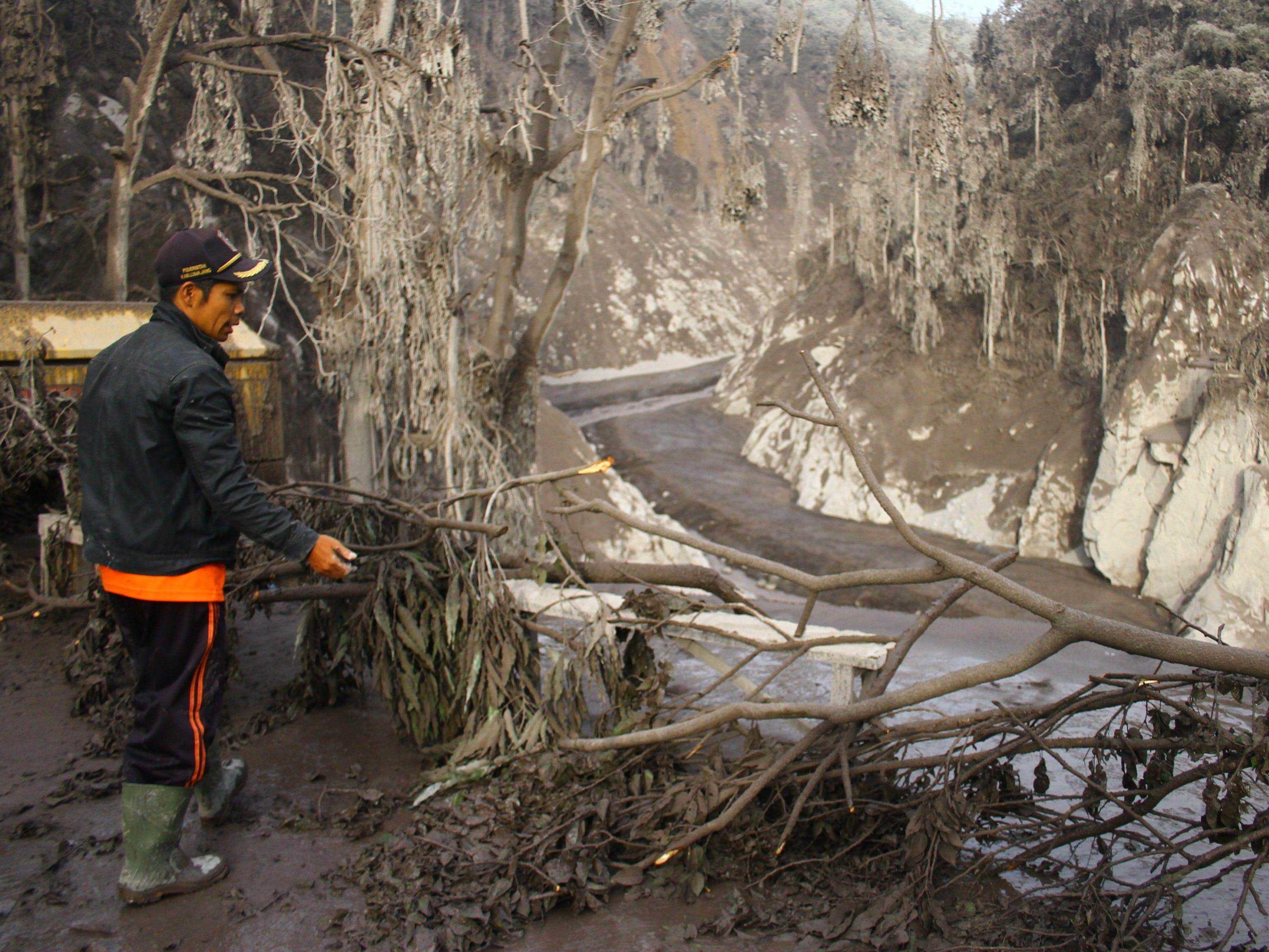 Ein indonesischer Rettungsoffizier steht in der Nähe einer kaputten Brücke, die vom Ausbruch des Mount Semeru im Dorf Candipuro, Lumajang, Indonesien, am 5. Dezember 2021 getroffen wurde.