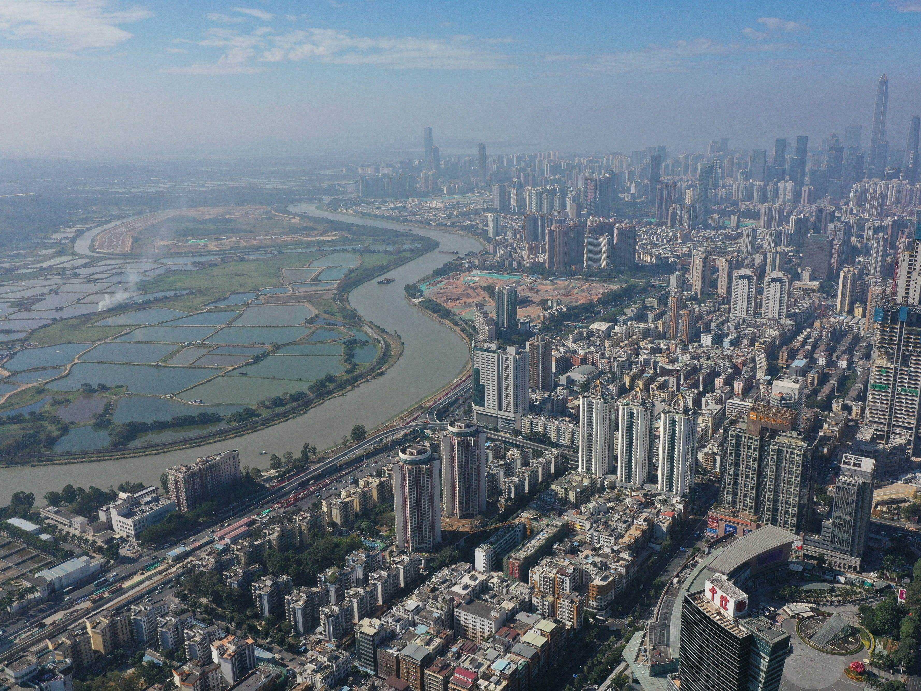 Luftaufnahme des Shenzhen-Flusses, der die Grenze zwischen Wohn- und Geschäftsgebäuden in Shenzhen (rechts) und Ackerland in Hongkong (links) am 29. Dezember 2020 markiert.