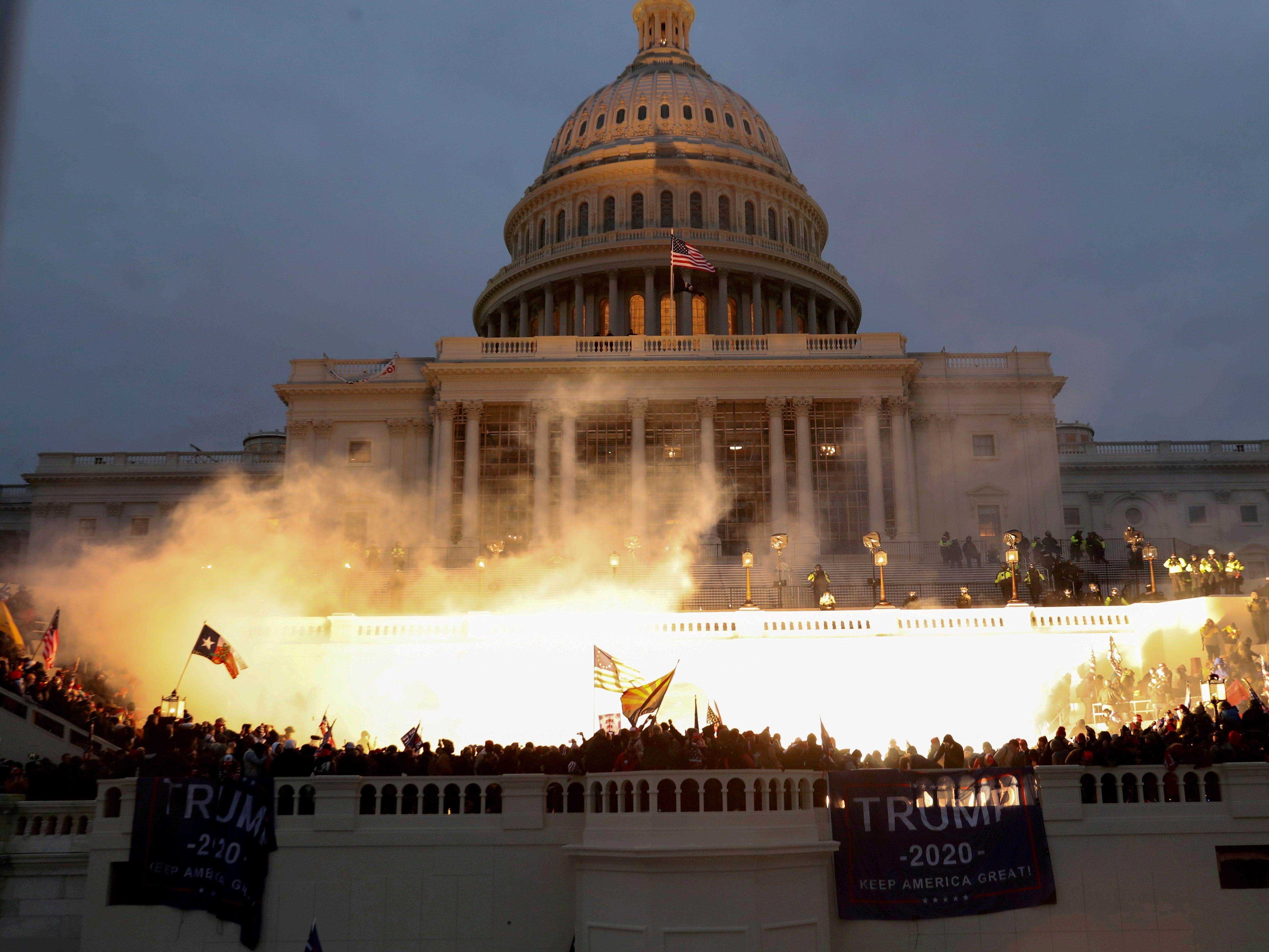 Eine durch Polizeimunition verursachte Explosion ist zu sehen, während Anhänger von US-Präsident Donald Trump am 6. Januar 2021 vor dem US Capitol Building in Washington, USA, randalieren.