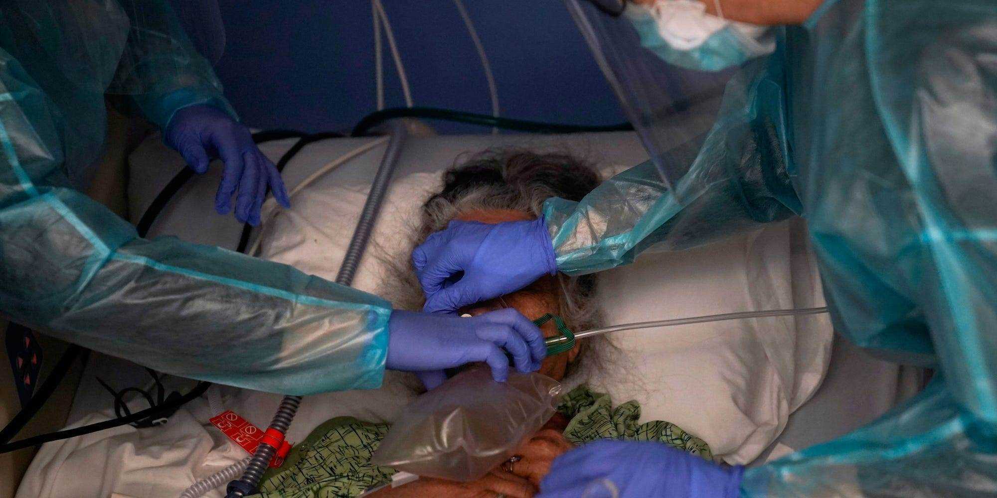 In diesem Aktenfoto vom 7. Januar 2021 setzen zwei Krankenschwestern einem Patienten in einer COVID-19-Einheit in Orange, Kalifornien, ein Beatmungsgerät ein.