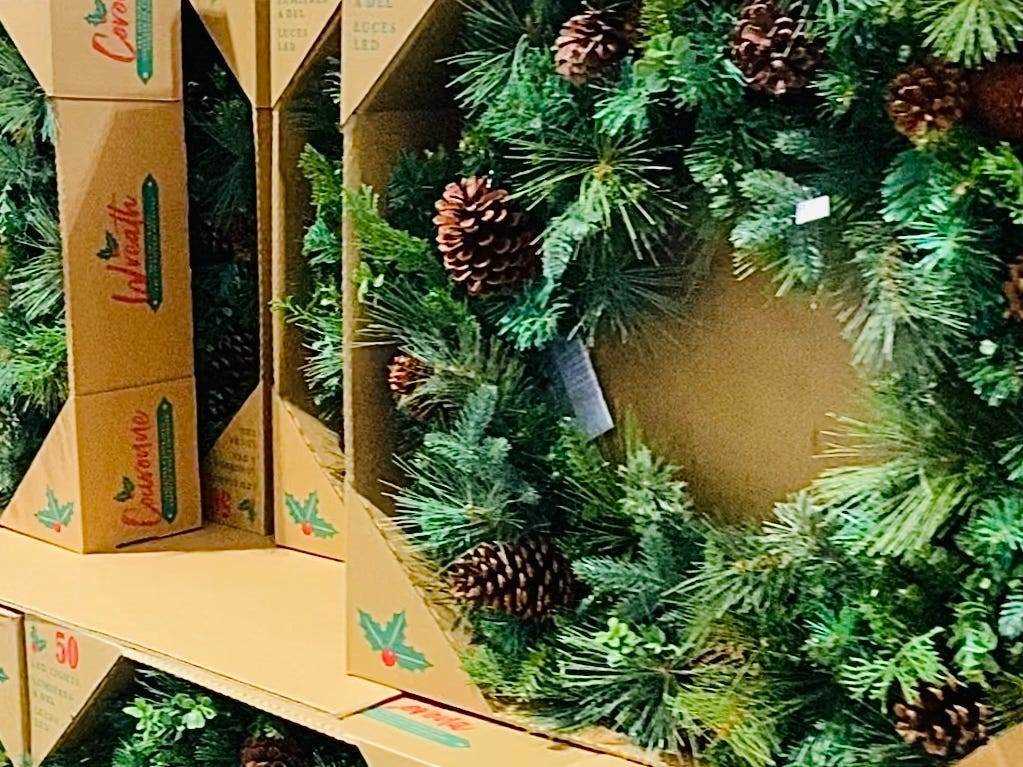 Weihnachtskränze mit Tannenzapfen in Regalen zum Preis