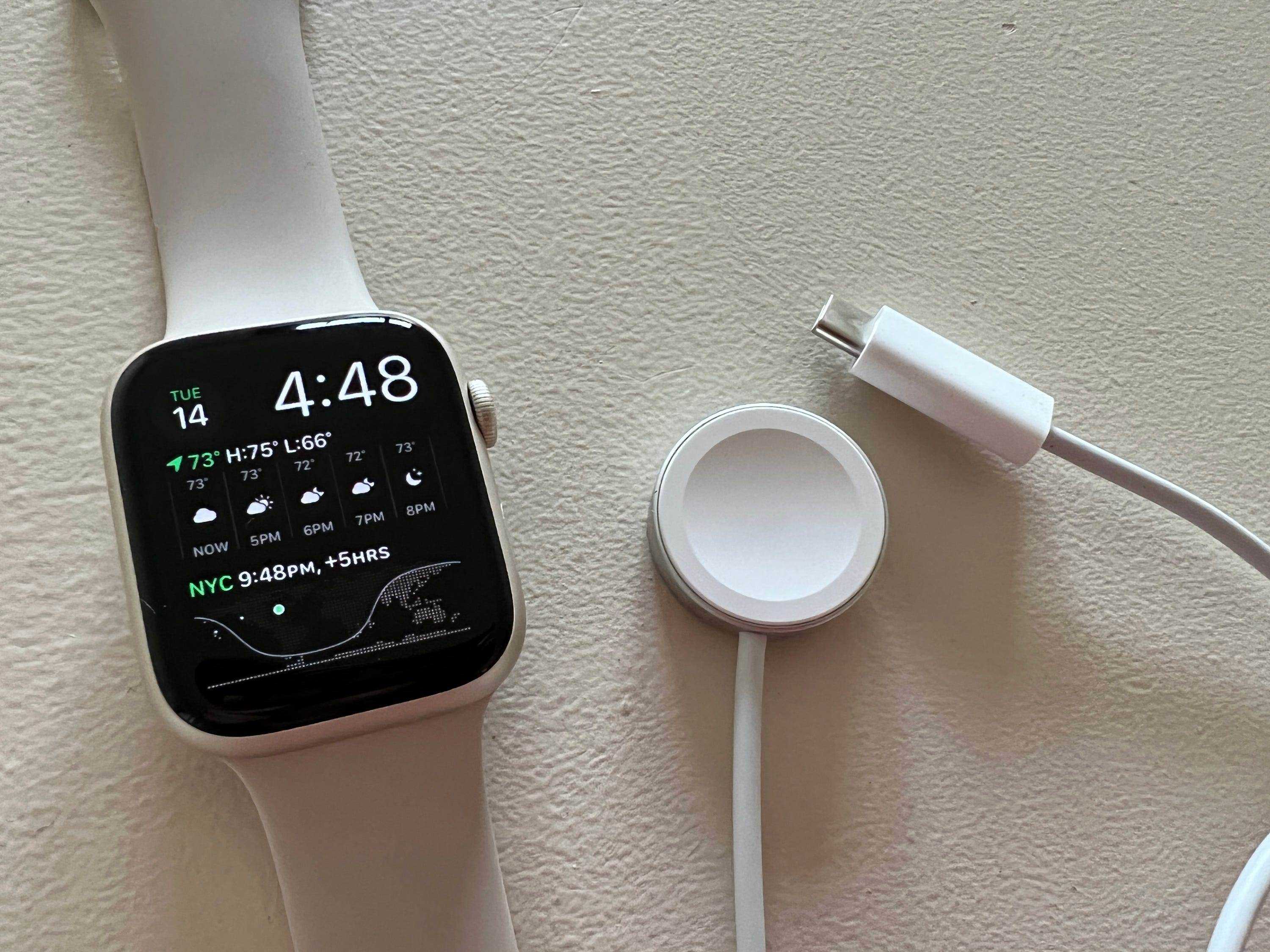 Die Apple Watch Series 7 neben ihrem neuen, schnelleren kabellosen USB-C-Ladegerät.