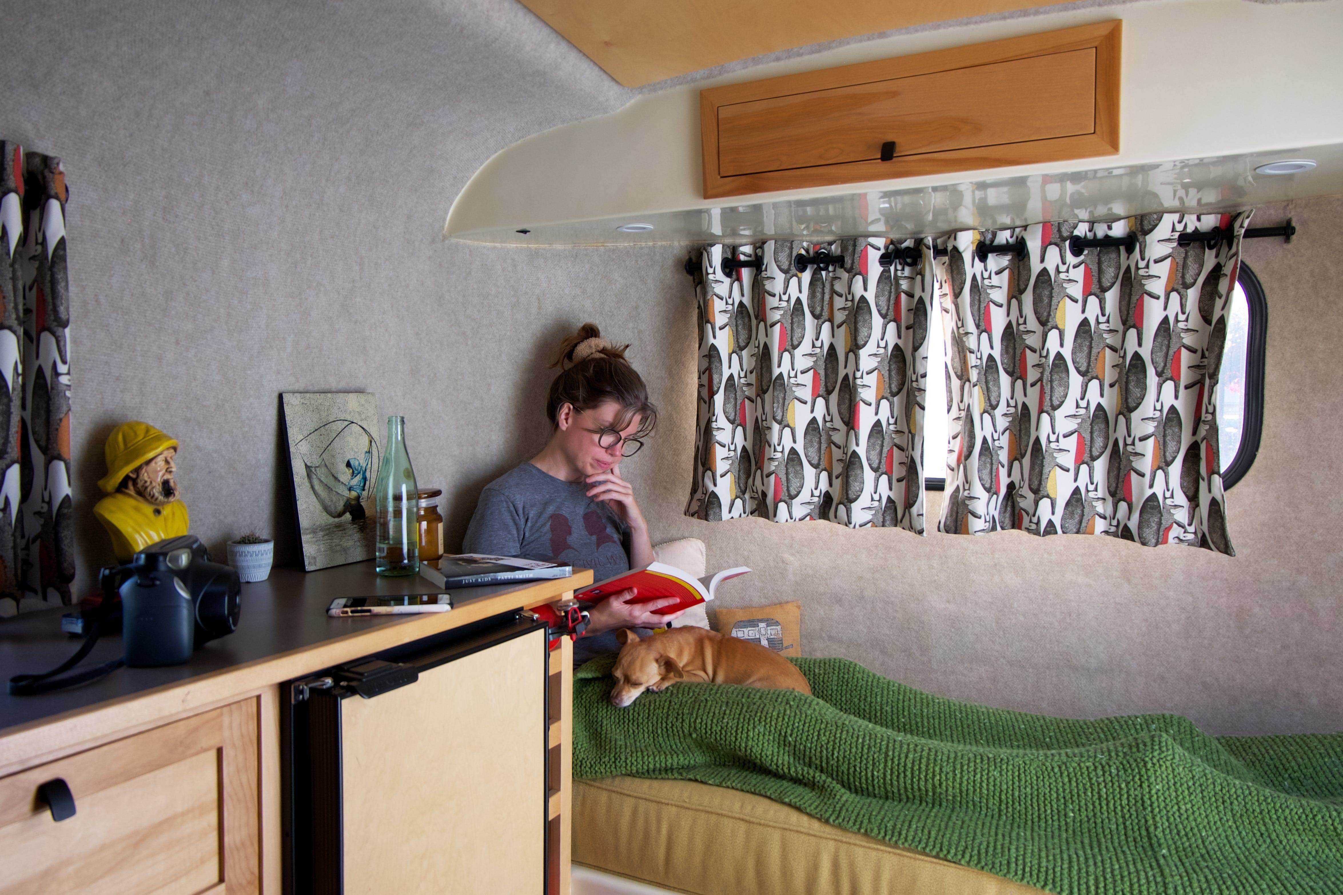 Eine Frau in einem Bett in einem Wohnwagen.
