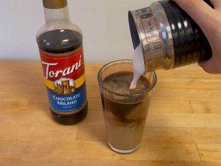 Ein bewegtes Bild vom Gießen von Schaum in eine Tasse Kaffee