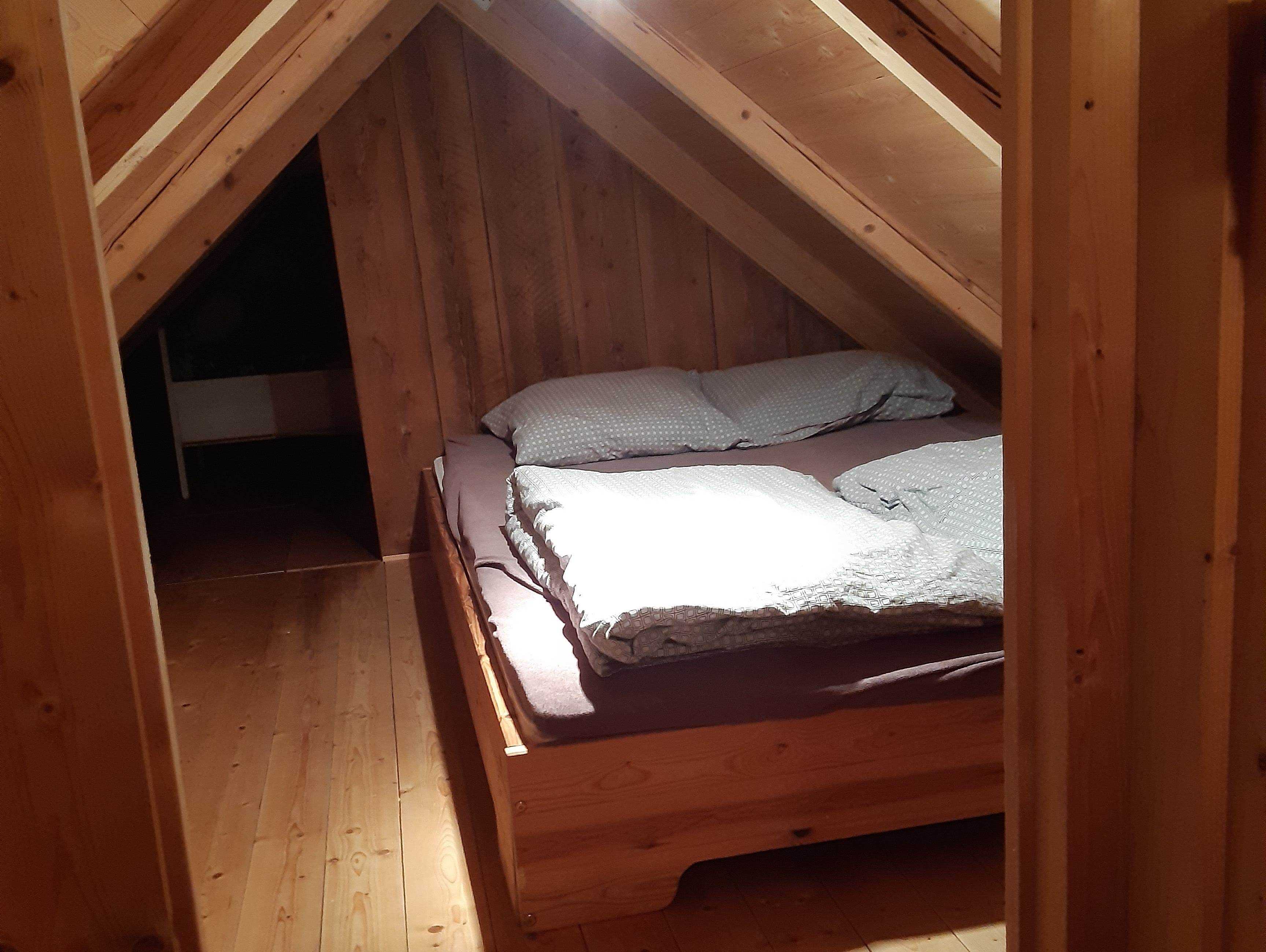Kleines holzverkleidetes Zimmer mit einem Bett im Inneren