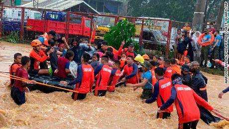 Retter helfen den Bewohnern bei der Überschwemmung, die durch den Taifun Rai verursacht wurde, als sie am 16. 