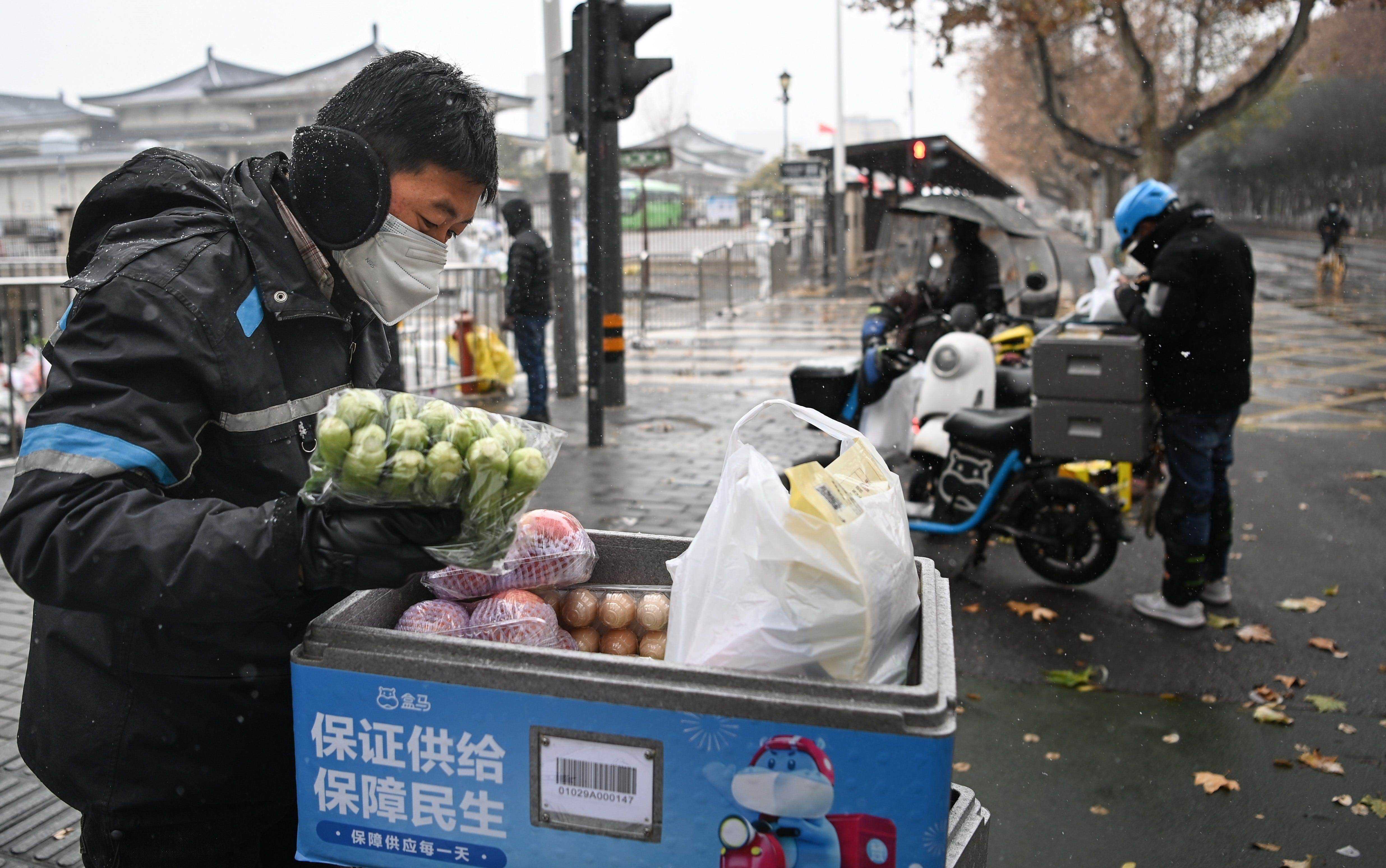 Lieferbote Zhang Xin liefert Gemüse in ein Wohngebiet unter abgesperrter Bewirtschaftung