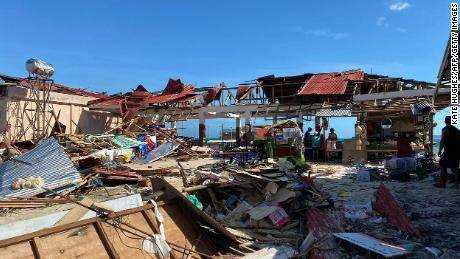 Einwohner stehen einen Tag nach der Verwüstung des Taifuns Rai neben einem zerstörten Marktgebäude in der Stadt General Luna auf der Insel Siargao in der Provinz Surigao del Norte.  
