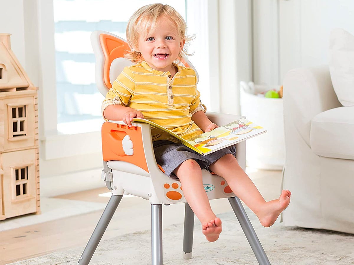 Kind sitzt auf orange-weißem Stuhl, Sitzlehne ähnelt einem Fuchs
