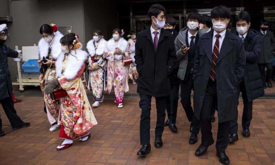 Zwanzig Jahre alte Männer und Frauen in Kimonos und Anzügen verlassen die Todoroki Arena, Japan, während des Coming of Age Day am 11. Januar 2021.